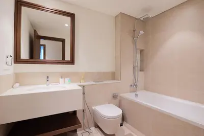 a bathroom with a sink and a toilet and a tub at Lux 1BR Beachfront Living Palace Beach Residence in Dubai
