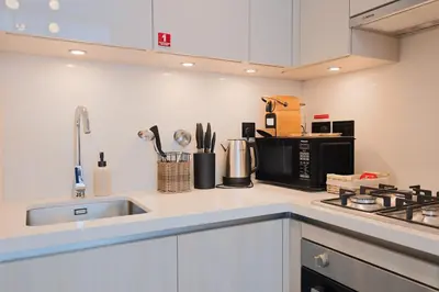a kitchen counter with a sink and a microwave at Stylish & Chic 1BR - The Crest at Sobha Hartland in Dubai