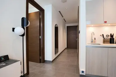 a hallway leading to a kitchen with a counter at Stylish & Chic 1BR - The Crest at Sobha Hartland in Dubai