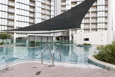 a large swimming pool in a large building at Stylish & Chic 1BR - The Crest at Sobha Hartland in Dubai