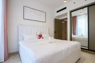 a bedroom with a white bed with a teddy bear on it at Prime 2BR in Binghatti Crest - JVC in Dubai