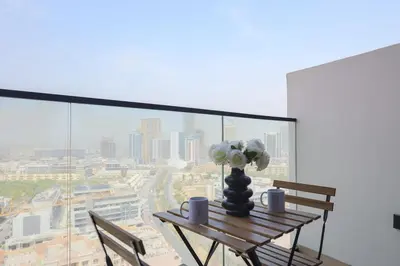 a table with a vase of flowers on top of a window at Prime 2BR in Binghatti Crest - JVC in Dubai