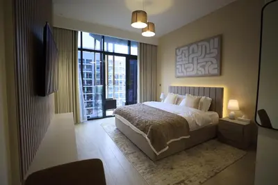 a bedroom with a bed and a large window at Modern and cozy studio apartment in Dubai