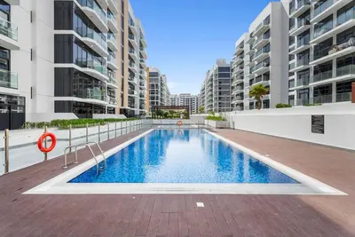 a swimming pool in the middle of a building with tall buildings at Modern and cozy studio apartment in Dubai