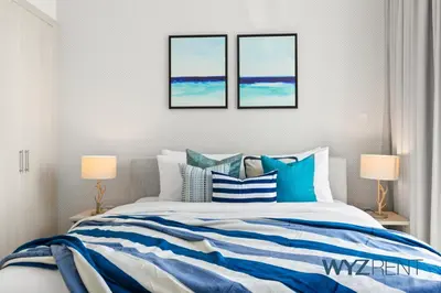 a bedroom with a blue and white bed with two lamps at Salt & Sand Hamptons Glow 2BR Sulafa Tower in Dubai