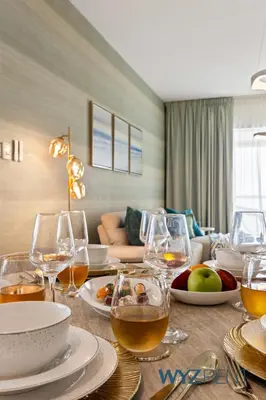 a dining table with wine glasses and food on it at Salt & Sand Hamptons Glow 2BR Sulafa Tower in Dubai
