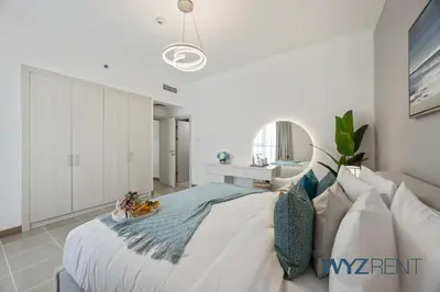 a white bedroom with a bed and a couch at Salt & Sand Hamptons Glow 2BR Sulafa Tower in Dubai