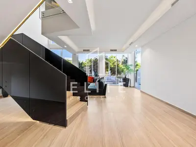 an open living room with a staircase and a couch at Luxury Ixora Family Villa in Dubai