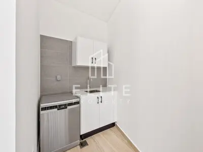 a white kitchen with a sink and a dishwasher at Luxury Ixora Family Villa in Dubai
