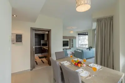 a dining room and living room with a table and chairs at Spacious - Stylish - Scenic Marina View in Dubai