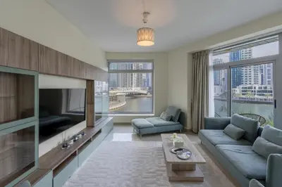 a living room with a couch and a tv at Spacious - Stylish - Scenic Marina View in Dubai