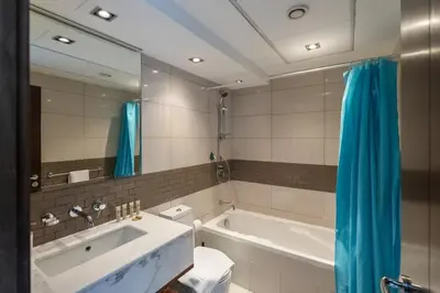 a bathroom with a tub and a sink and a mirror at Spacious - Stylish - Scenic Marina View in Dubai