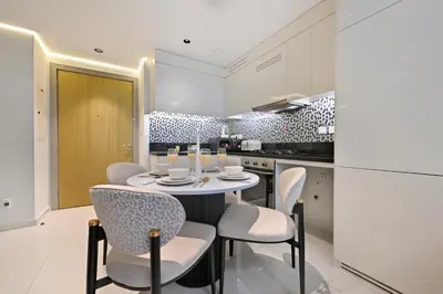 a kitchen and dining room with a table and chairs at High Floor 2 Bedroom Apartment - Exclusive Luxury at Aykon Tower - PlayStation 5 in Dubai