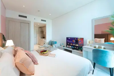 a living room with a bed and a tv at Luxury Studio with Private Beach Access - Palm Jumeirah in Dubai