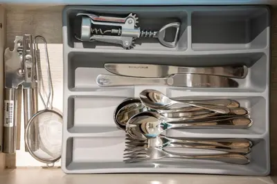a drawer filled with silver utensils on a counter at Luxury Studio with Private Beach Access - Palm Jumeirah in Dubai
