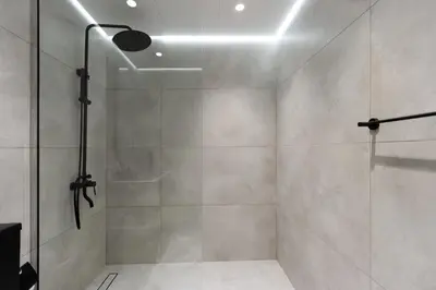 a bathroom with a shower with a glass door at Newly Upgraded 2BR - Steps from Burj Khalifa and Opera in Dubai