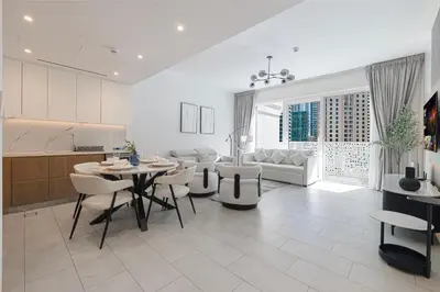 a kitchen and living room with a table and chairs at La Vie Seaside with Beach Access in Dubai