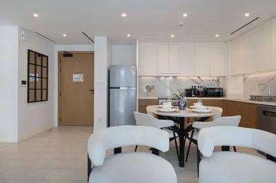 a kitchen with a table and chairs and a refrigerator at La Vie Seaside with Beach Access in Dubai