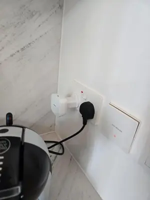 a black cord plugged into an outlet in a wall at Luxury 1BR with Scenic Views - Palace Residence in Dubai