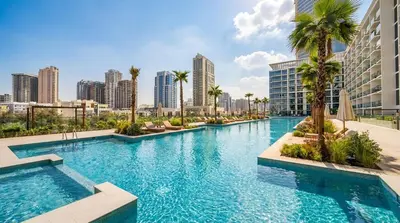 a large swimming pool with palm trees and buildings at Binghatti Phoenix! Longest Pool in Dubai! Brand New Building, 2 Double Beds! in Dubai