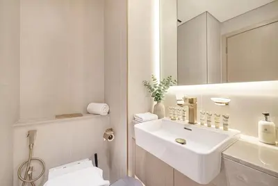 a white bathroom with a sink and a toilet at Binghatti Phoenix! Longest Pool in Dubai! Brand New Building, 2 Double Beds! in Dubai
