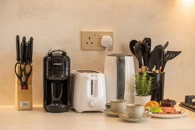 a counter with a coffee maker and other kitchen utensils at Binghatti Phoenix! Longest Pool in Dubai! Brand New Building, 2 Double Beds! in Dubai