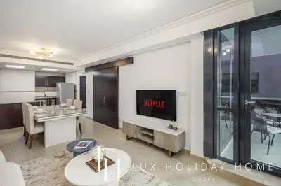 a living room with a tv and a table at LUX The JLT Gold Crest Suite in Dubai