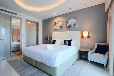 a bedroom with a large white bed and a chair at 904 DAMAC Paramount in Dubai
