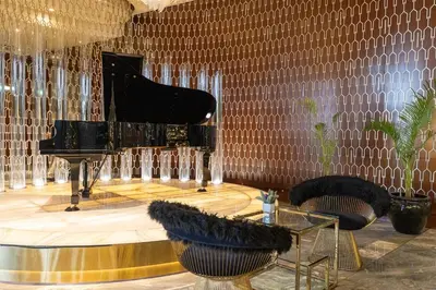 a room with a piano and two chairs and a table at 904 DAMAC Paramount in Dubai