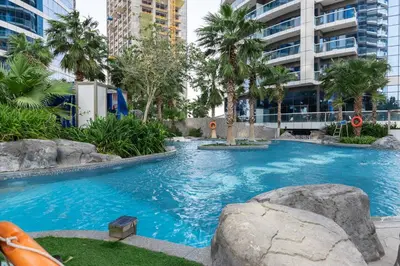 a large swimming pool in a building with palm trees at 904 DAMAC Paramount in Dubai