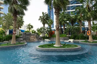 a swimming pool with palm trees in a resort at 904 DAMAC Paramount in Dubai