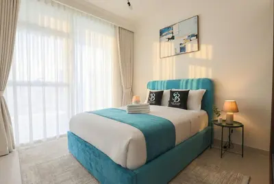 a bedroom with a large bed with a blue headboard at Lux 2BR Beachfront Escape Palace Beach Residence in Dubai