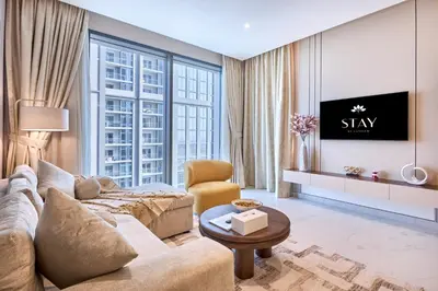 a living room with a couch and a tv at STAY BY LATINEM Luxury 1BR Holiday Home CVG2403 Near Downtown in Dubai