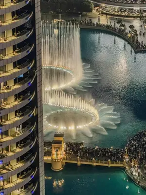 an aerial view of a fountain in a pool with a building at Ultra Luxury 4BR 7P Burj and Fountain View in Dubai