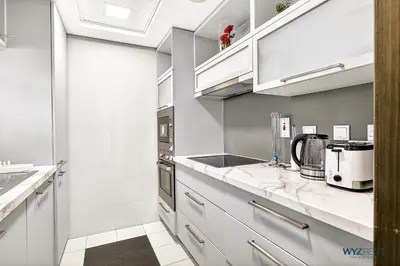 a kitchen with white cabinets and a sink at Upscale 1BR Loft Central Walk to Burj Khalifa&Mall in Dubai