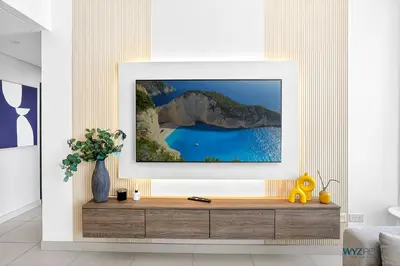 a living room with a tv on a wall at Upscale 1BR Loft Central Walk to Burj Khalifa&Mall in Dubai