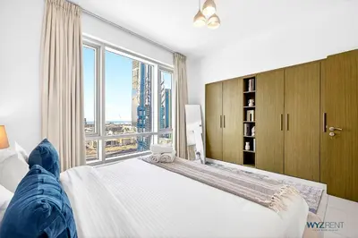 a bedroom with a large bed with a large window at Upscale 1BR Loft Central Walk to Burj Khalifa&Mall in Dubai