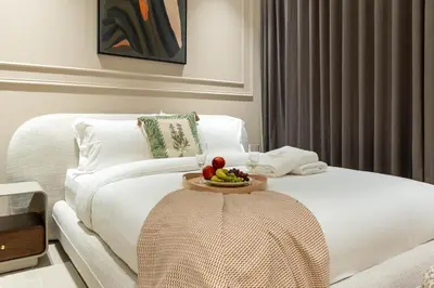 a white bed with a tray of fruit on it at Luxury Apartment in JVC with Private Balcony Pool in Dubai