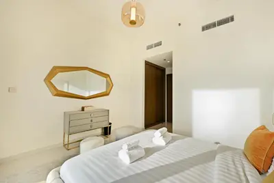 a bedroom with a white bed and a mirror at BLVD Beachfront Living with Skyline View in Dubai