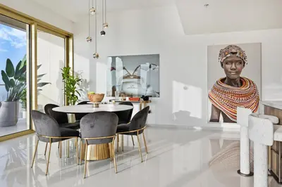 a dining room with a table and chairs and a statue at BLVD Beachfront Living with Skyline View in Dubai