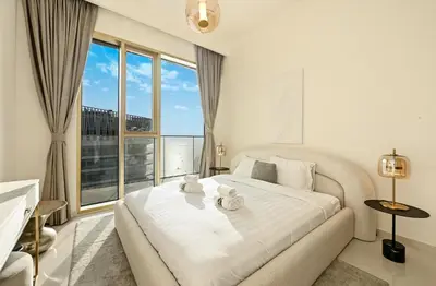 a white bedroom with a large bed and a large window at BLVD Beachfront Living with Skyline View in Dubai