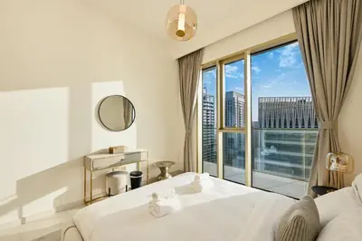 a bedroom with a bed and a large window at BLVD Beachfront Living with Skyline View in Dubai