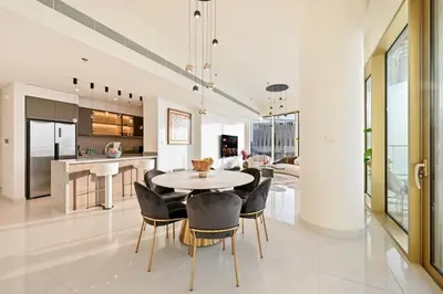 a kitchen and dining room with a table and chairs at BLVD Beachfront Living with Skyline View in Dubai