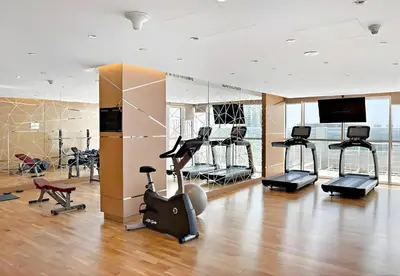 a gym with several treadmills and exercise bikes at Mahenti - Stunning Golf View Studio in Damac Hills in Dubai