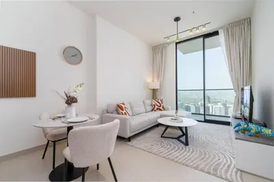 a living room with a couch and tables and a tv at High Floor JVC 1BR Skyline Showstopper in Dubai