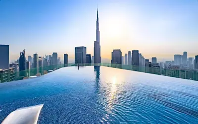 a infinity pool with a view of a city at Luxury 2BR - Paramount Midtown with Infinity Pool in Dubai