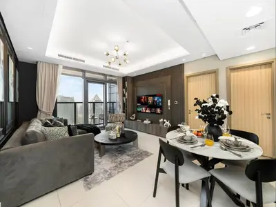 a living room with a couch and a table at Luxury 2BR - Paramount Midtown with Infinity Pool in Dubai