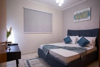 a bedroom with a bed with blue and white pillows at Luxury 2BR Haven with Panoramic Scenery in Dubai