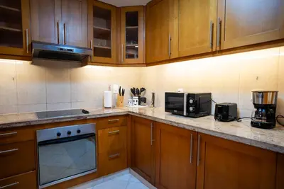 a kitchen with wooden cabinets and a counter top at Luxury 2BR Haven with Panoramic Scenery in Dubai