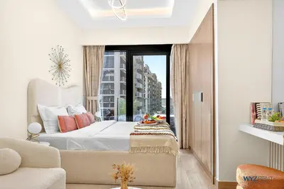 a bedroom with a bed and a large window at Winter Wonderland Studio Azizi Riviera 9 Pool View in Dubai